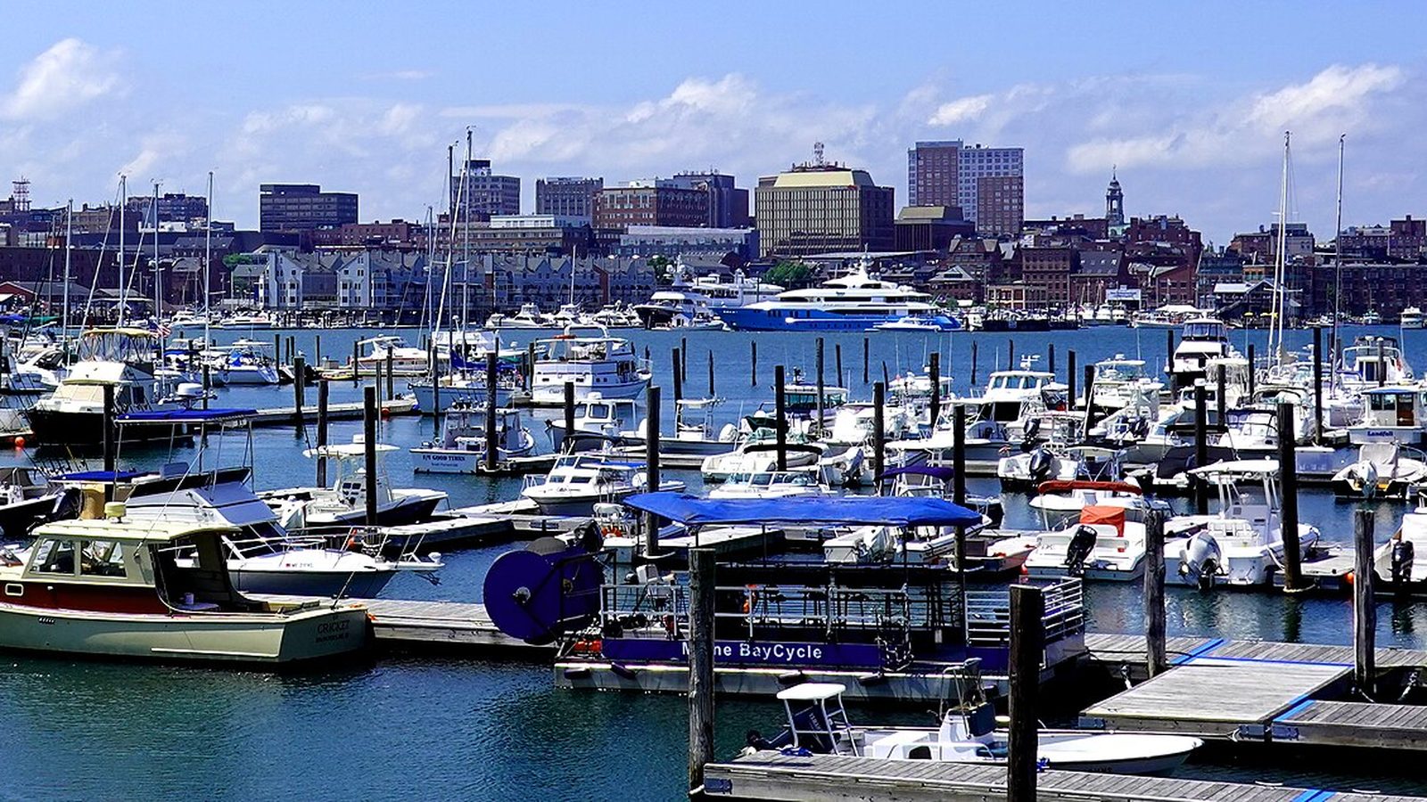 Boats in Portland harbor with the downtown Portland, Maine skyline behind them